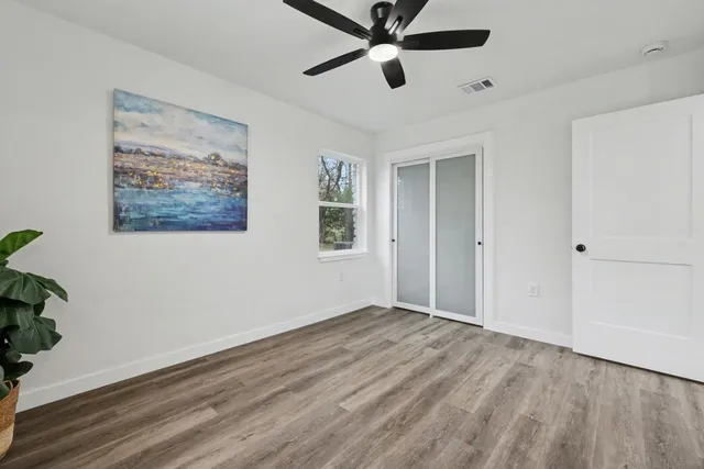 a view of a room with wooden floor and windows