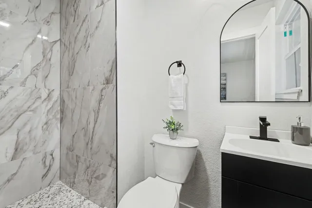 an empty room with wooden floor closet and windows
