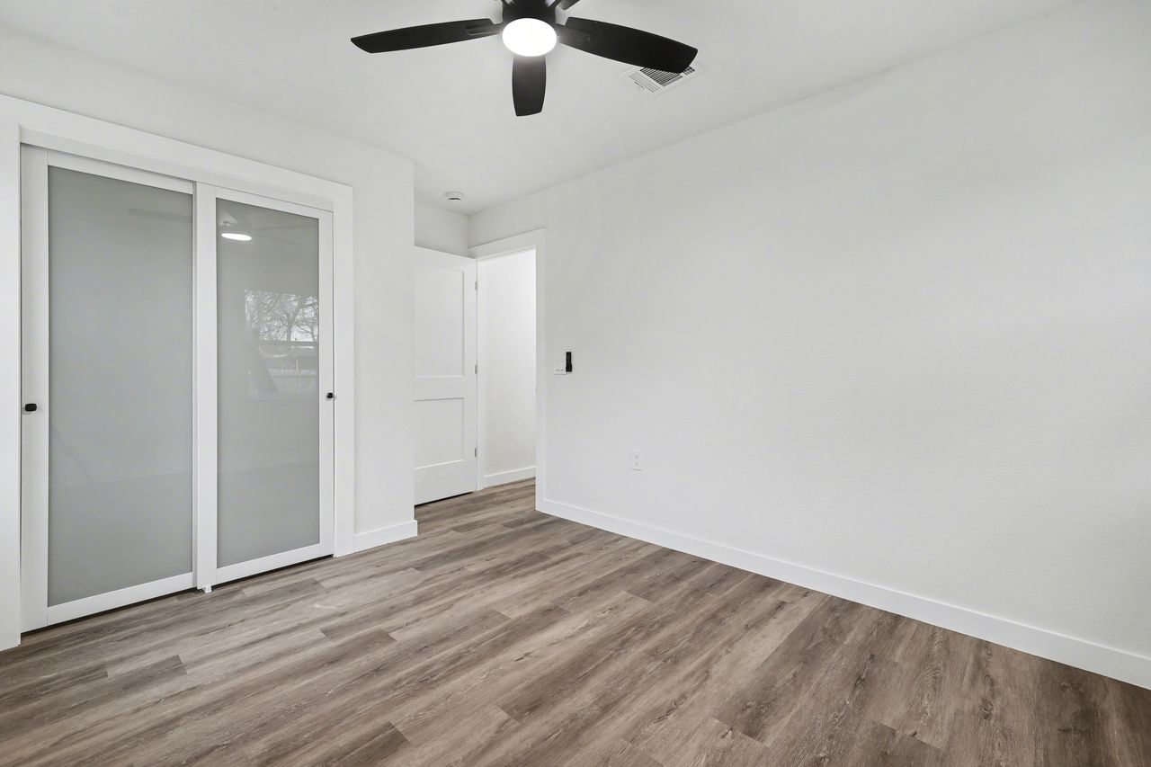 2103 Fordham Cove Austin, TX 78723 - Photo 24 of 36 an empty room with wooden floor closet and windows