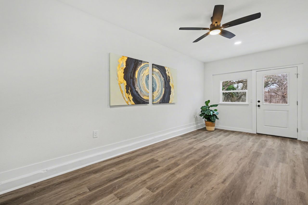 2103 Fordham Cove Austin, TX 78723 - Photo 27 of 36 a view of an empty room with window and wooden floor