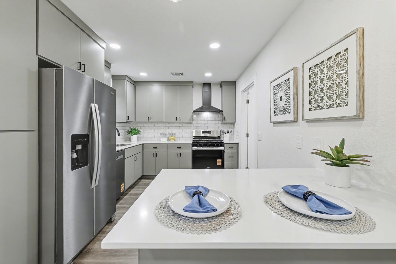 2103 Fordham Cove Austin, TX 78723 - Photo 7 of 36 a kitchen with stainless steel appliances granite countertop a refrigerator sink and white cabinets