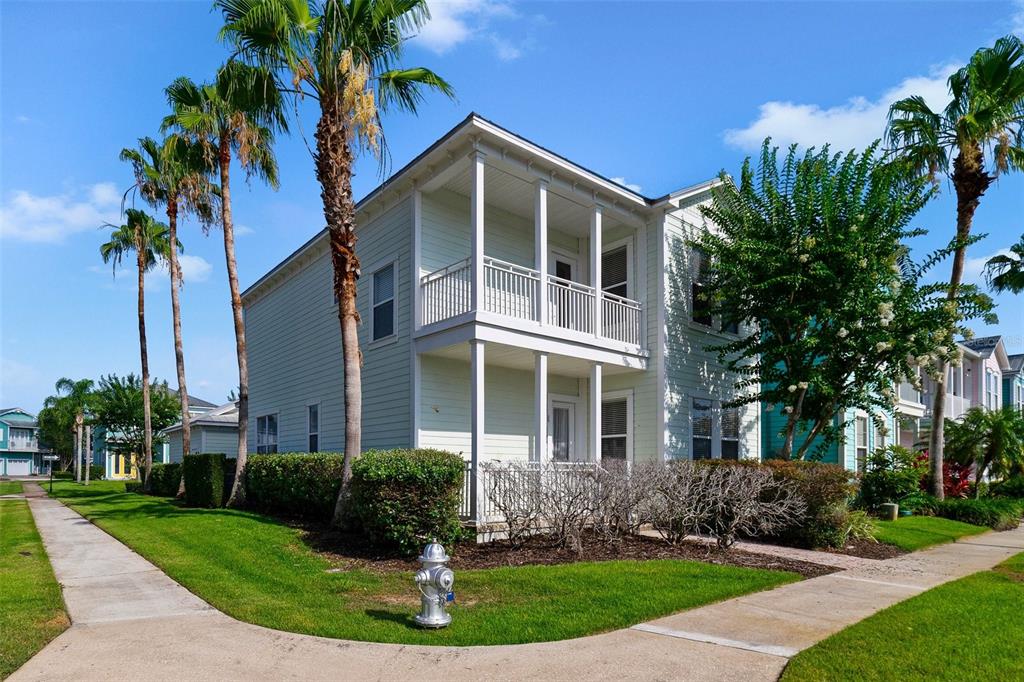 front view of a house with a yard and palm trees