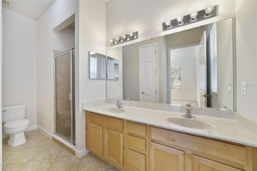 7740 Linkside Loop Reunion, FL 34747 - Photo 14 of 34 a bathroom with a sink double vanity granite and a toilet