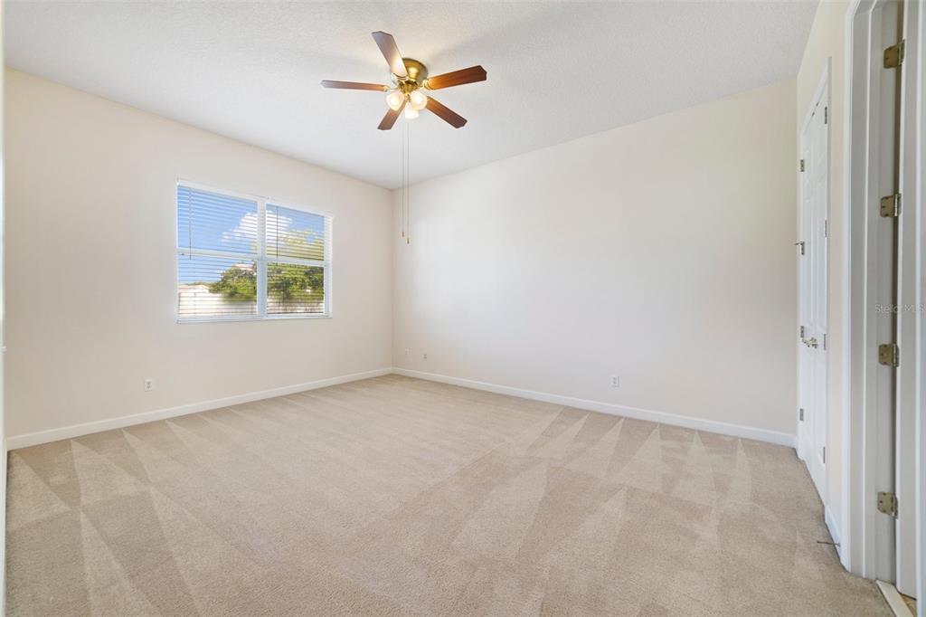 7740 Linkside Loop Reunion, FL 34747 - Photo 21 of 34 an empty room with a window and a ceiling fan
