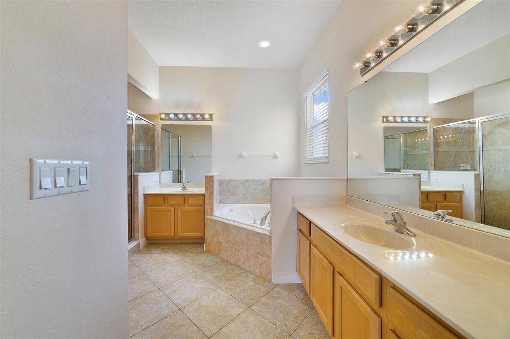 7740 Linkside Loop Reunion, FL 34747 - Photo 25 of 34 a spacious bathroom with a granite countertop sink a toilet a mirror and bathtub