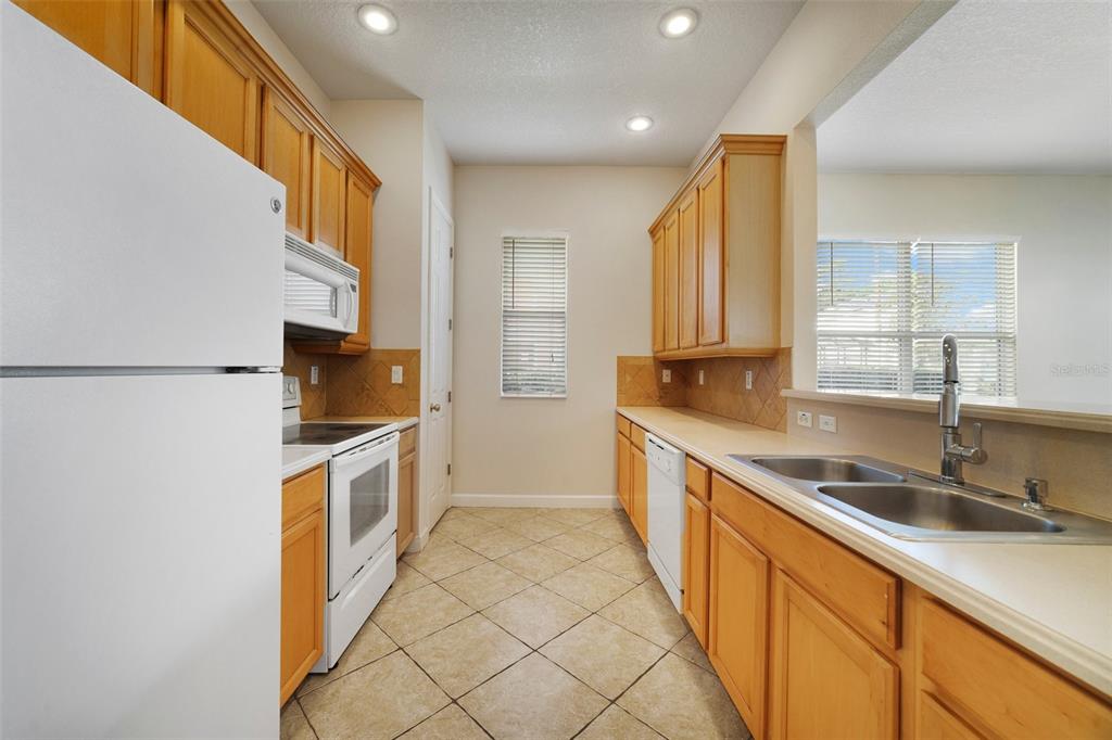 7740 Linkside Loop Reunion, FL 34747 - Photo 10 of 34 a kitchen with stainless steel appliances granite countertop a sink and a stove