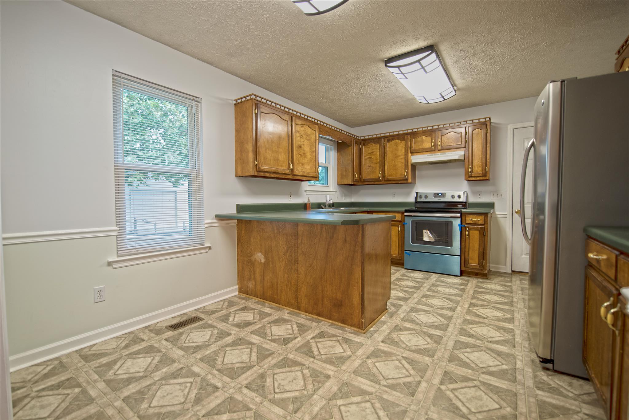 7500 Joe Rowlin Road Christiana, TN 37037 - Photo 13 of 22 a kitchen with stainless steel appliances granite countertop a stove a sink and a refrigerator