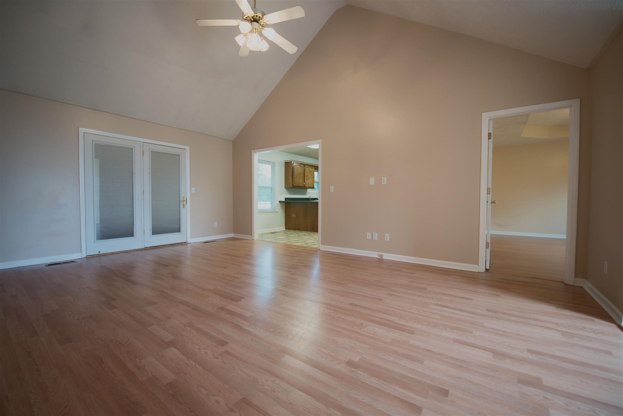 7500 Joe Rowlin Road Christiana, TN 37037 - Photo 10 of 22 an empty room with wooden floor chandelier fan and windows