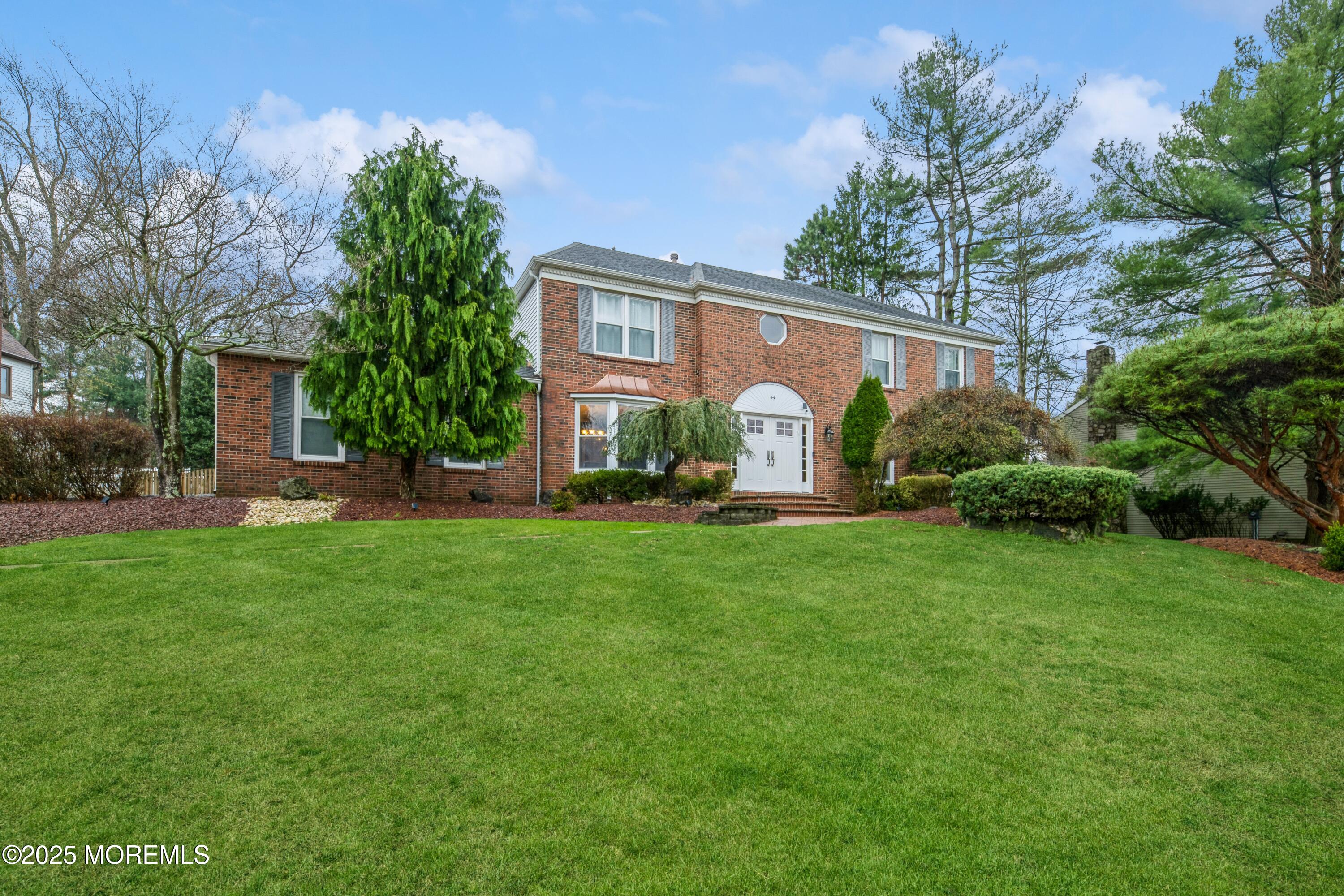 a view of a house with backyard and a tree