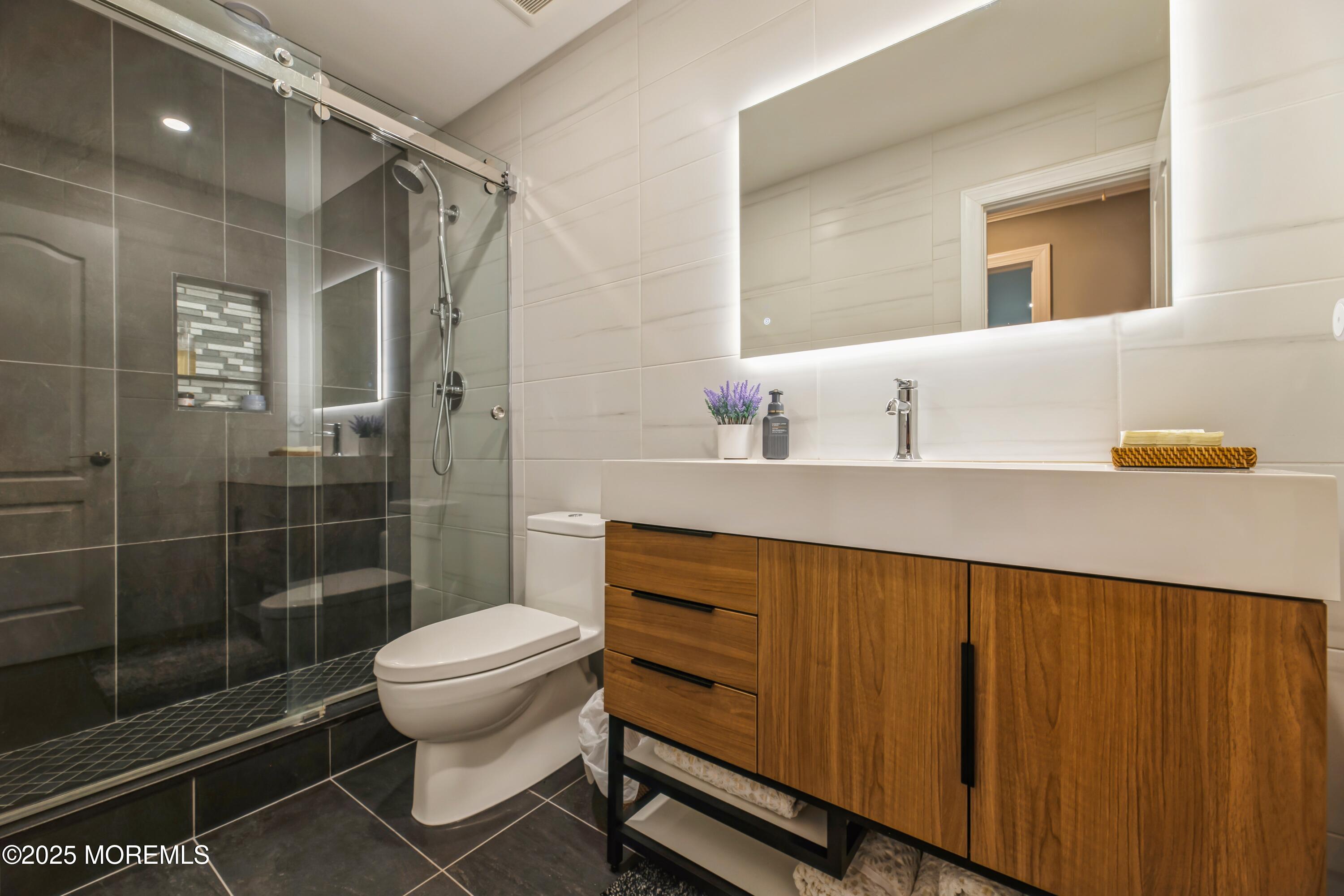 44 Manor Drive Marlboro, NJ 07746 - Photo 18 of 26 a bathroom with a sink a toilet and shower