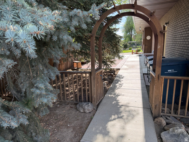 362 East 9150th Street South Sandy, UT 84070 - Photo 37 of 41 Arched wooden entryway with a concrete pathway and brick exterior