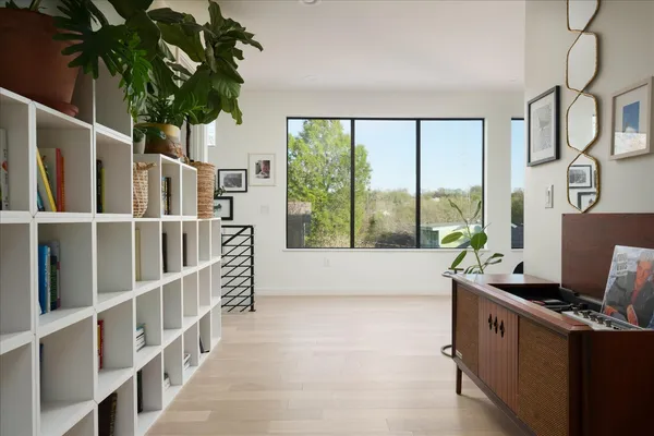 a bedroom with a bed couch and two windows