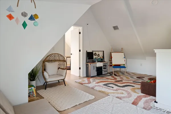 a bedroom with a bed and a dresser with rug