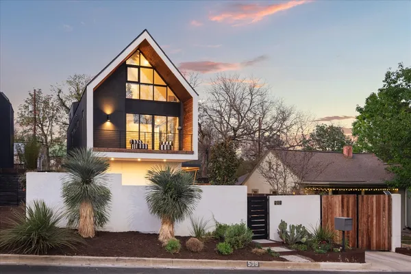 a front view of a house with a yard and potted plants
