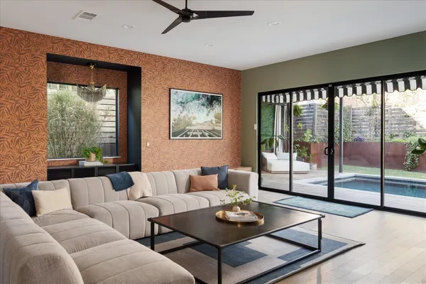 a living room with furniture and paintings on the wall next to a window