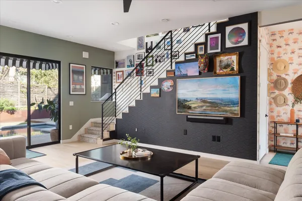 a living room with stainless steel appliances furniture and a kitchen view