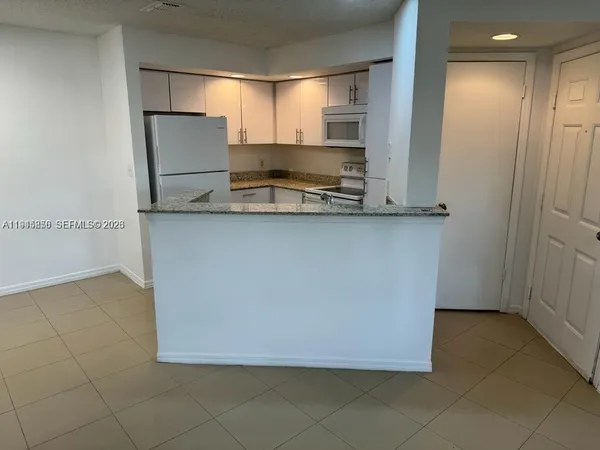 a view of cabinets with stainless steel appliances granite countertop window