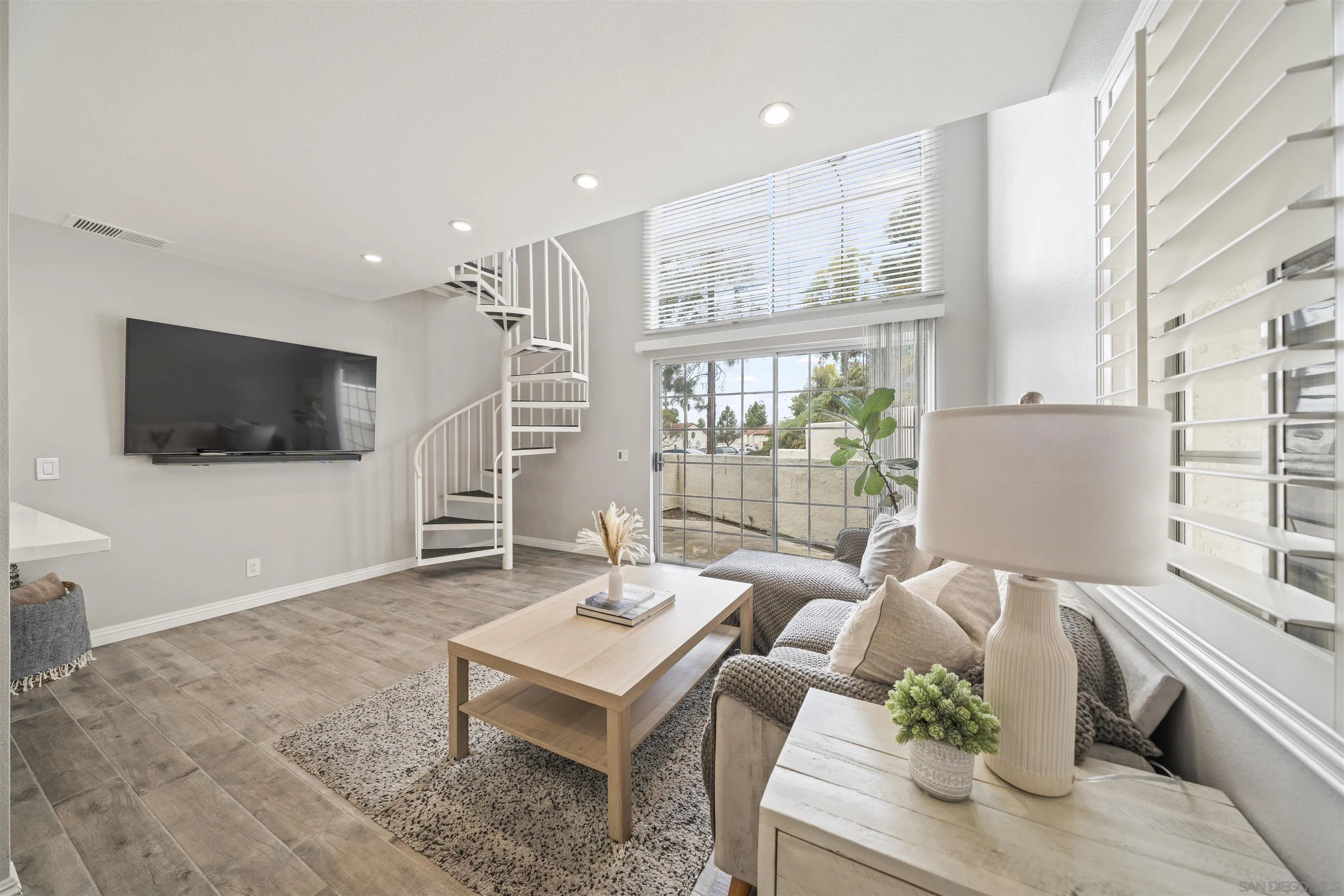 a living room with furniture a flat screen tv and large window