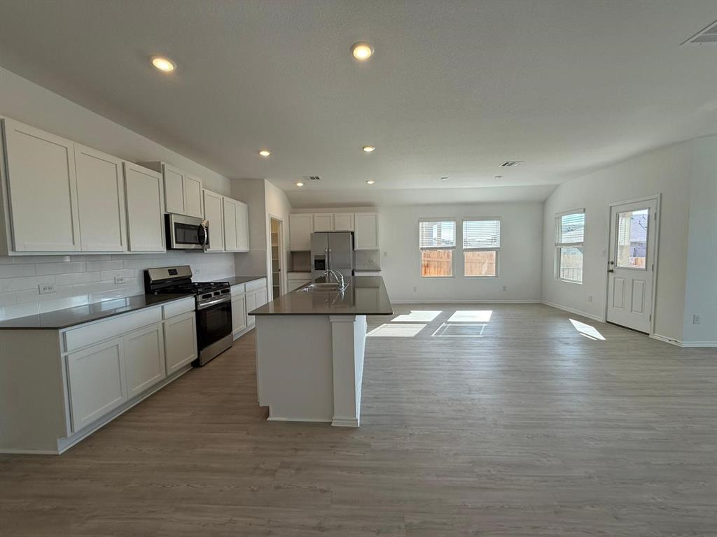 263 Magalia Lane Kyle, TX 78640 - Photo 18 of 37 a kitchen with sink cabinets and wooden floor