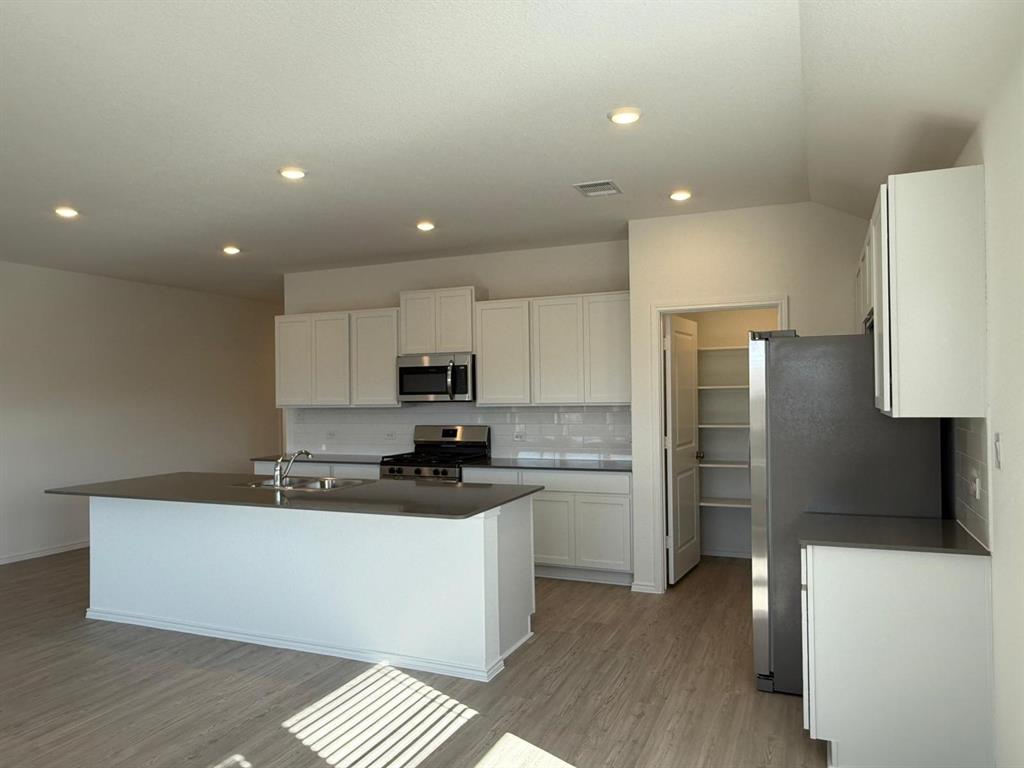 263 Magalia Lane Kyle, TX 78640 - Photo 21 of 37 a kitchen with stainless steel appliances a refrigerator sink and microwave