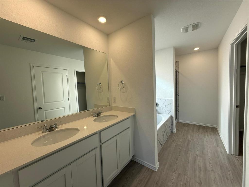 263 Magalia Lane Kyle, TX 78640 - Photo 26 of 37 a bathroom with a sink double vanity granite tub shower and a mirror