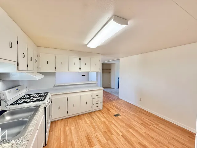 a kitchen with granite countertop a stove and a sink