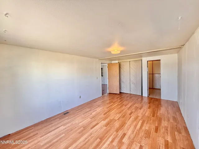 a view of an empty room with wooden floor
