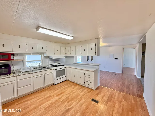 a large kitchen with stainless steel appliances granite countertop a stove and a sink
