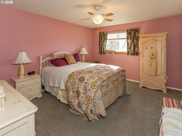 a spacious bedroom with a bed and a chandelier