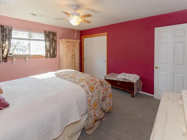 a view of an empty room with closet and a window