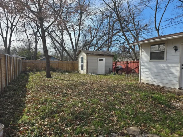 a backyard of a house with plants and tree