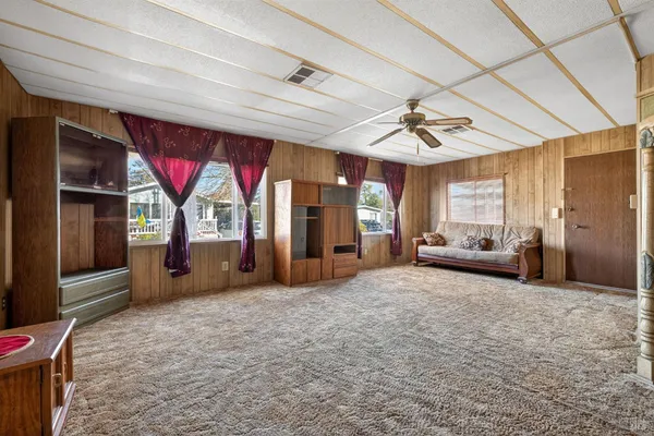 a view of a livingroom with furniture window and a ceiling fan