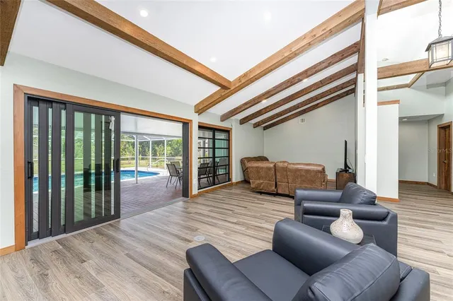 a kitchen with stainless steel appliances granite countertop a table chairs in it and wooden floors