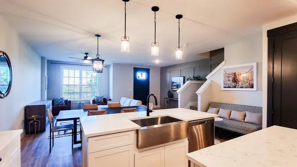 a view of a dining room and livingroom with furniture wooden floor a chandelier