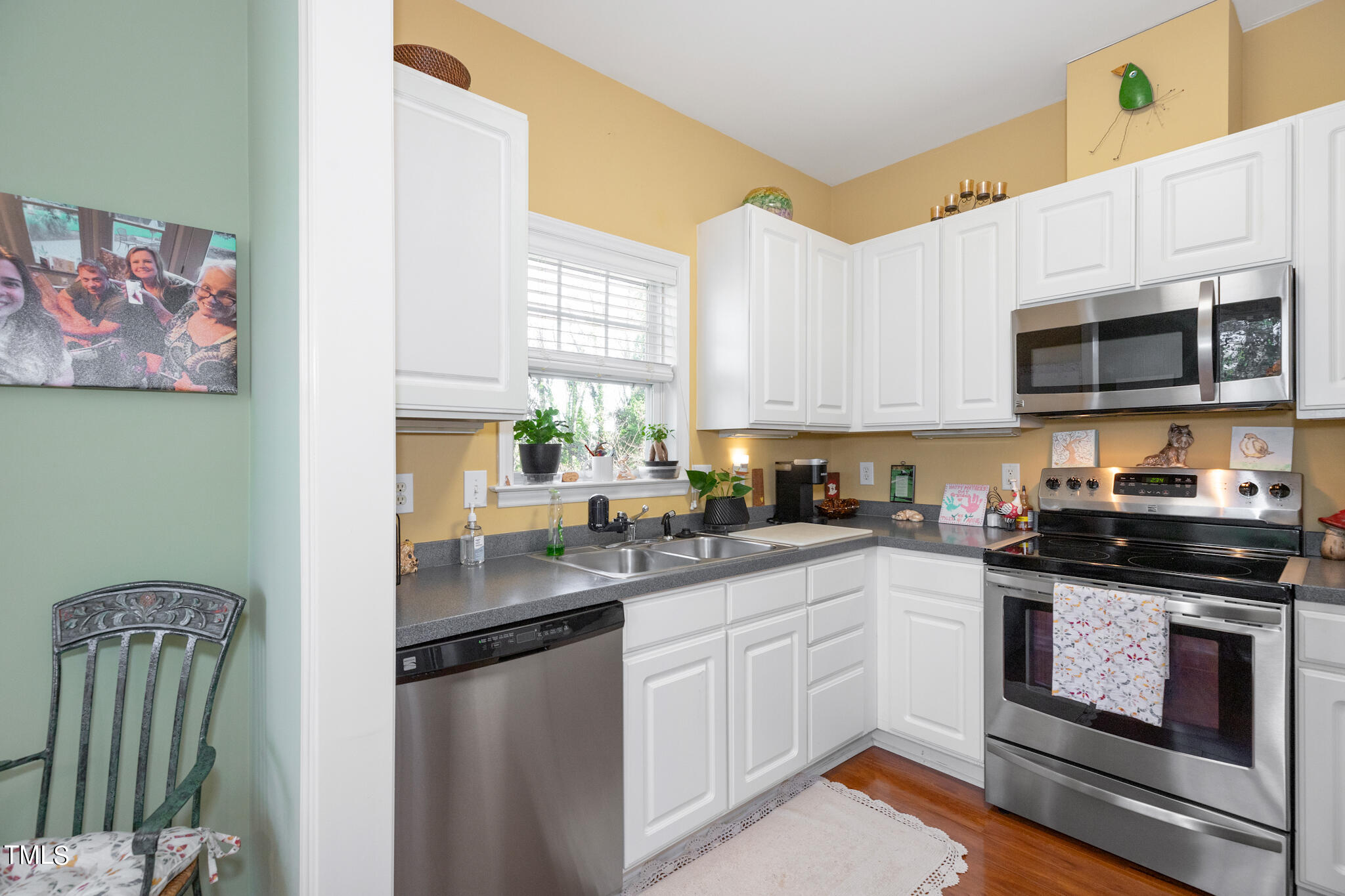 1700 Tiffany Bay Court, Unit 303 Raleigh, NC 27609 - Photo 14 of 30 a kitchen with stainless steel appliances granite countertop a stove a sink and a microwave