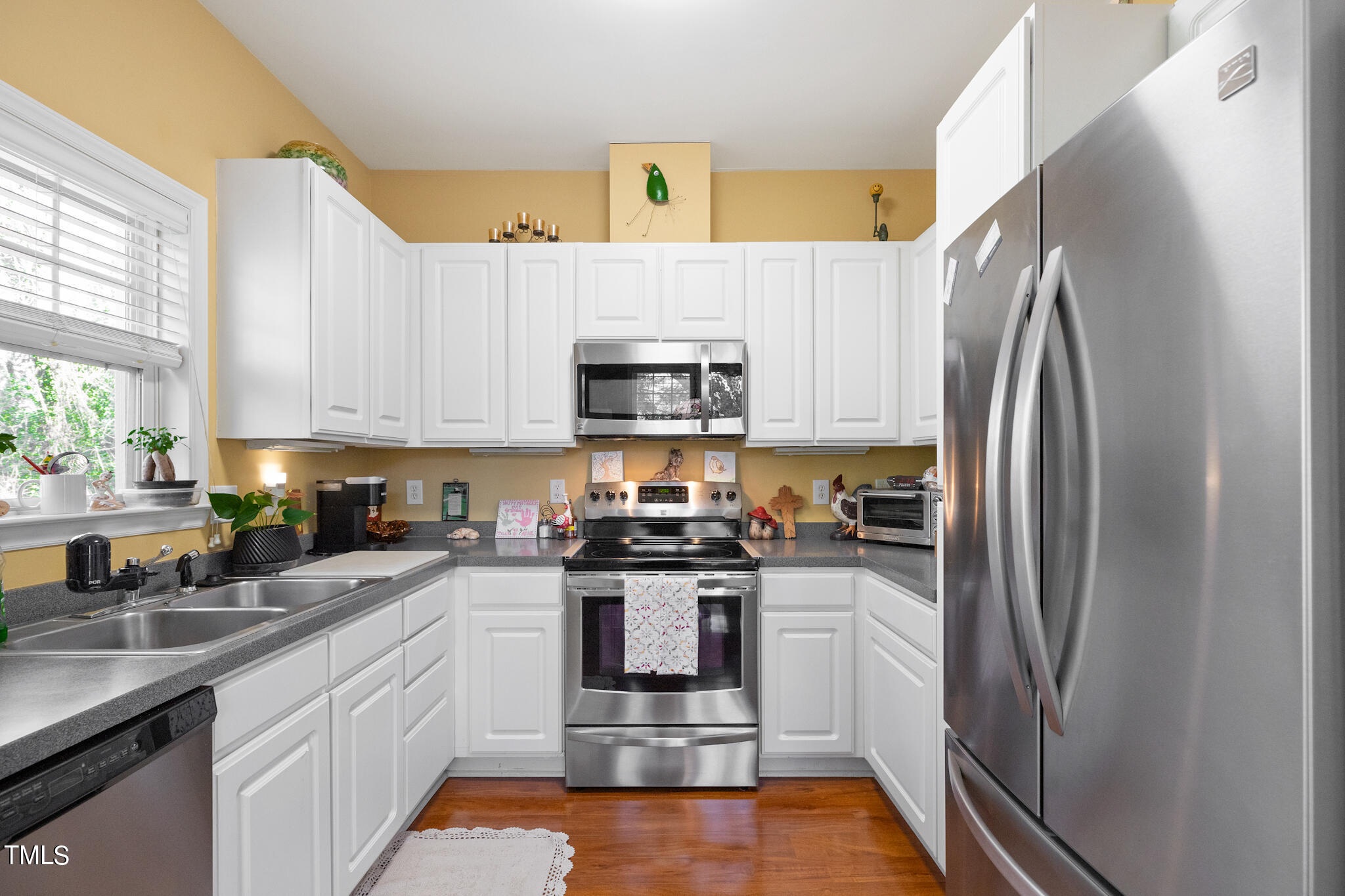1700 Tiffany Bay Court, Unit 303 Raleigh, NC 27609 - Photo 15 of 30 a kitchen with stainless steel appliances granite countertop a refrigerator sink and stove