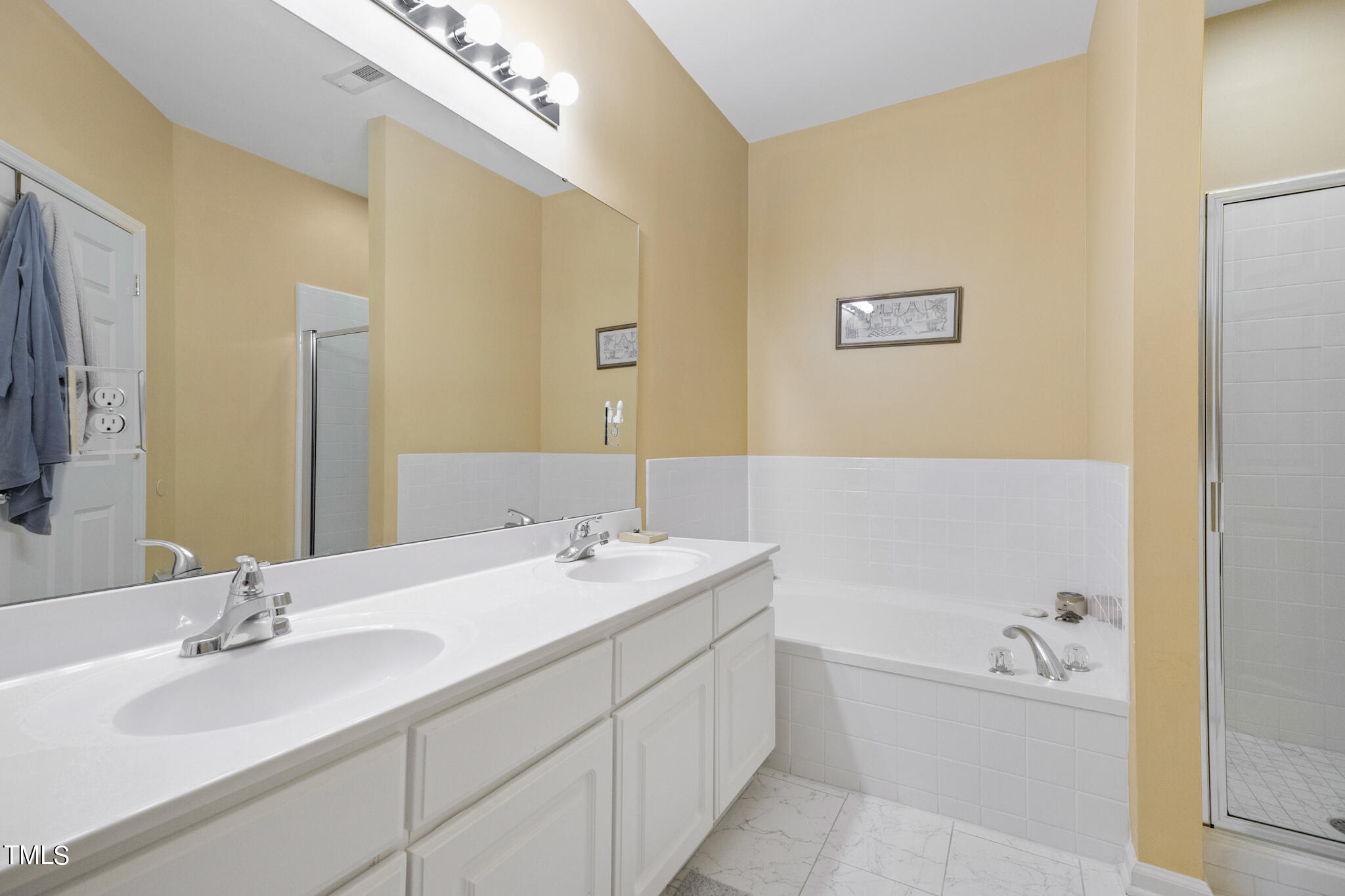 1700 Tiffany Bay Court, Unit 303 Raleigh, NC 27609 - Photo 28 of 30 a bathroom with a tub sink double vanity and a mirror