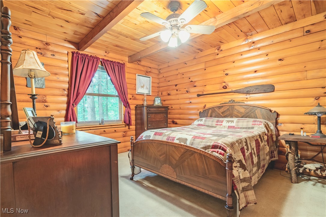 49144 Hickman Road Calcutta, OH 43920 - Photo 15 of 23 Carpeted bedroom featuring beamed ceiling, ceiling fan, log walls