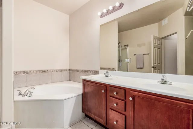 a bathroom with a tub double sink and mirror