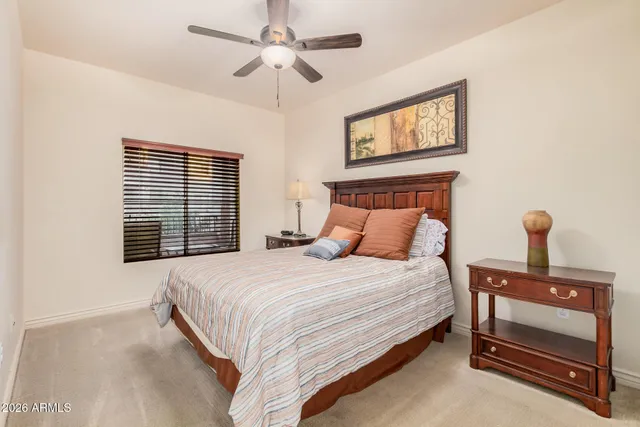 a bedroom with a bed a window and a chandelier