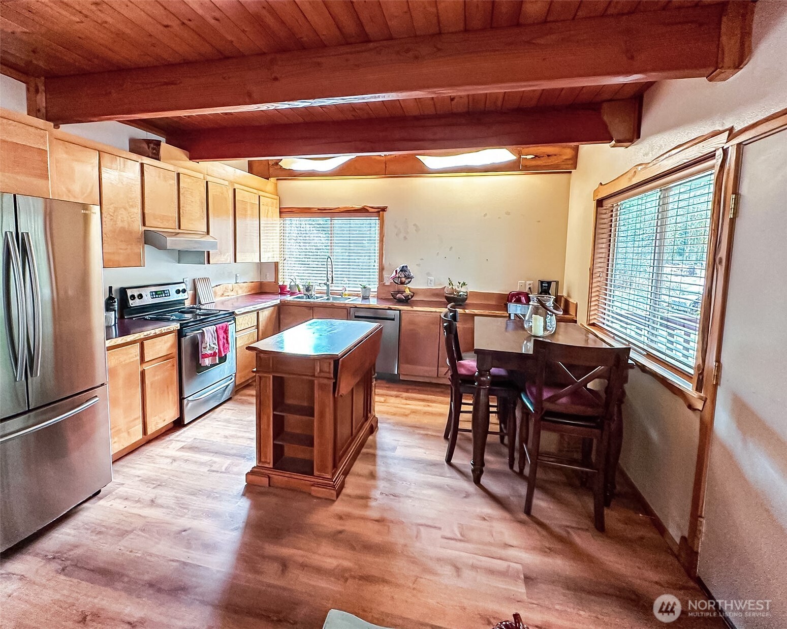 132 Findley Road Morton, WA 98356 - Photo 2 of 28 a large dining hall with stainless steel appliances granite countertop a stove kitchen island a dining table and chairs with wooden floor
