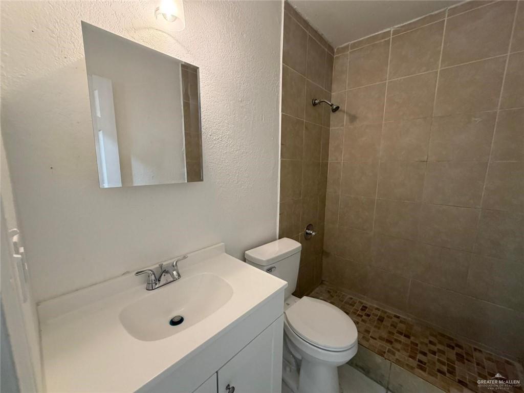 2612 West Mile 17 1/2 Road, Unit 12 Edinburg, TX 78541 - Photo 8 of 10 White tile flooring with dark grout lines, a ceiling fan with integrated lighting, and bi-fold closet doors-Virtualy Staged