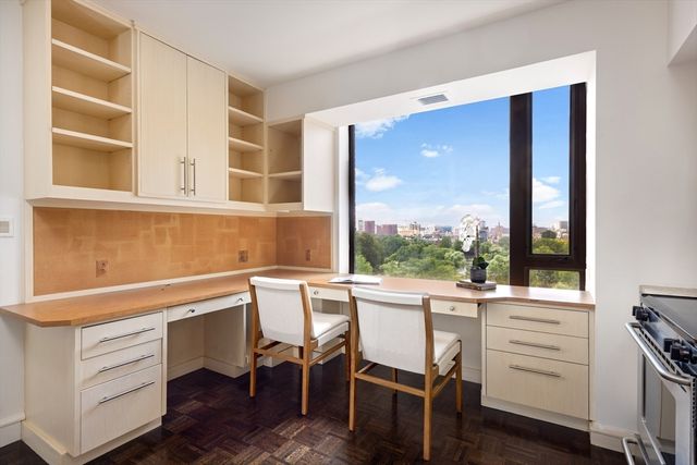 a view of a workspace with furniture and a window