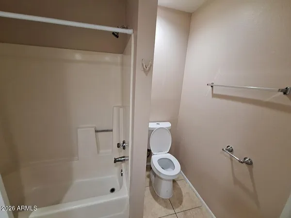 a white toilet sitting next to a bath tub