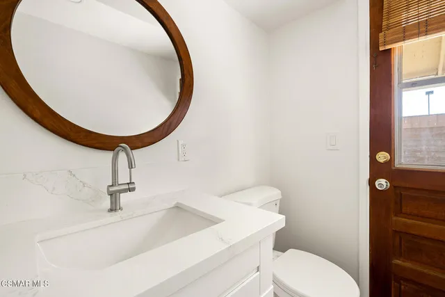a bathroom with a sink a toilet and mirror