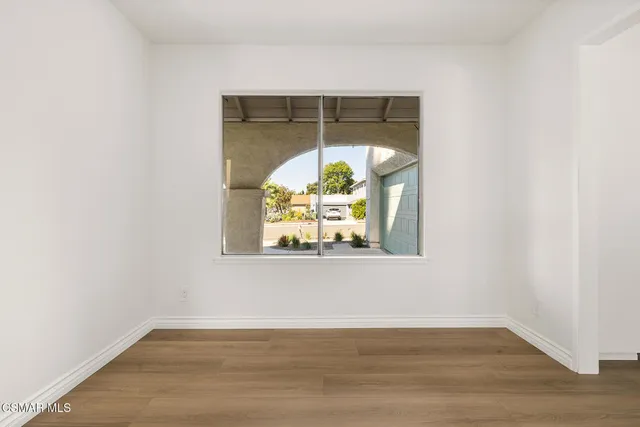 an empty room with window and wooden floor