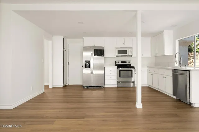 a view of kitchen with wooden floor and electronic appliances