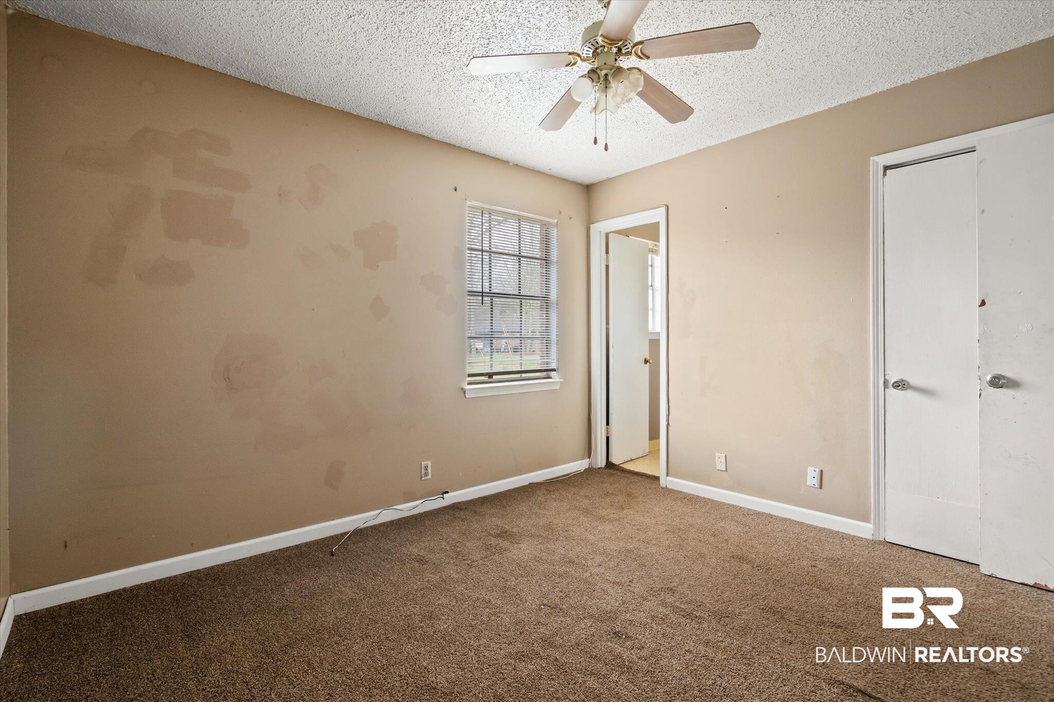 313 West 4th Avenue Foley, AL 36535 - Photo 9 of 20 Unfurnished bedroom with ceiling fan, carpet, and a textured ceiling