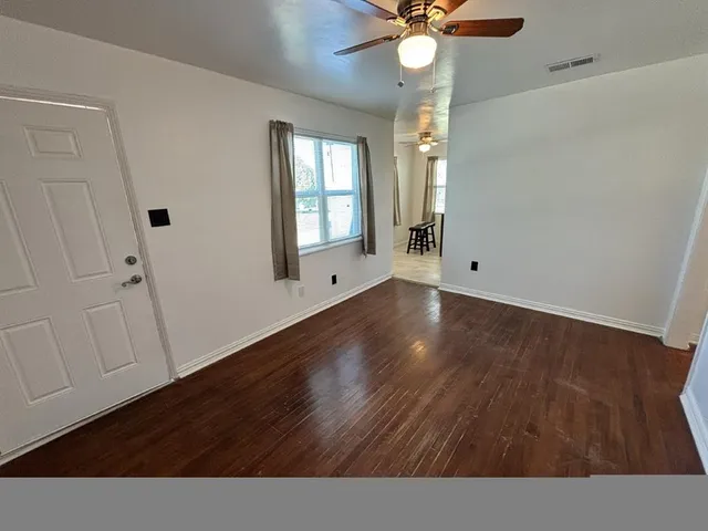 wooden floor in an empty room with a window