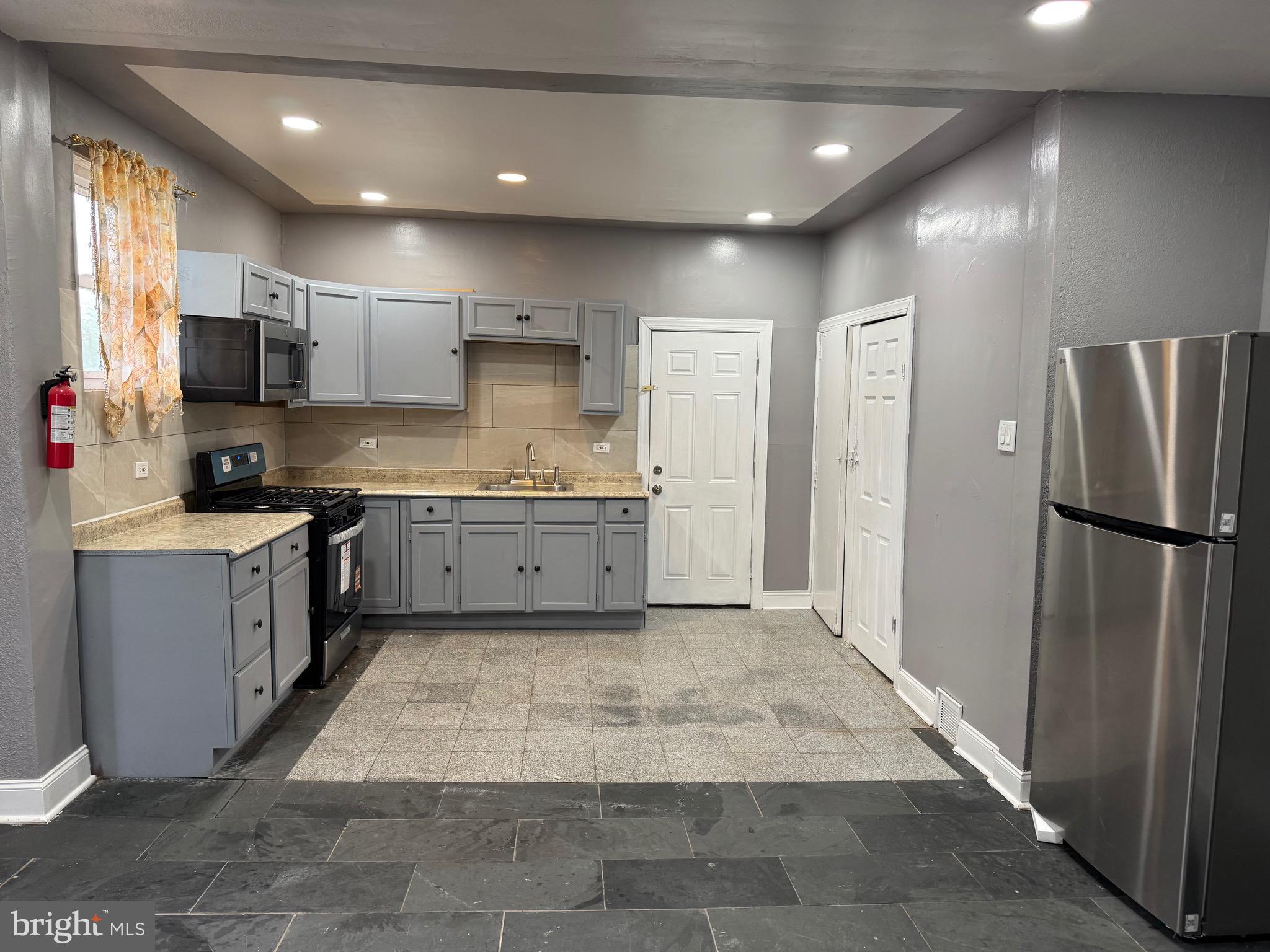 132 Walnut Street Colwyn, PA 19023 - Photo 4 of 43 a large kitchen with cabinets and stainless steel appliances